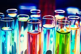Row of colourful test tubes filled with liquids of various hues, symbolising experimentation and discovery in science education.